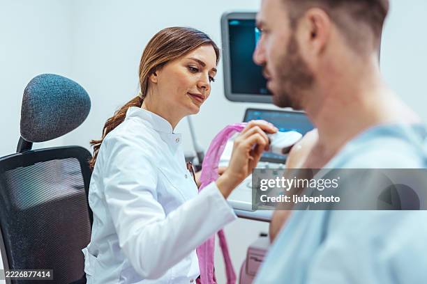medical professional conducting ultrasound on patient in clinical environment - ultrasound technician stock pictures, royalty-free photos & images