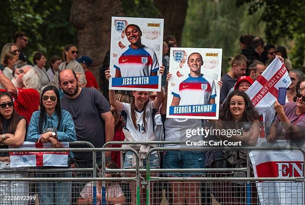 Fans hold placards along The Mall during the England Women's football team open-top bus victory parade and celebration on July 29, 2025 in London,...