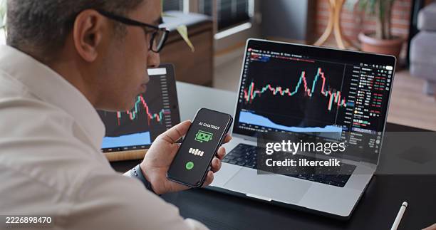uomo che utilizza ai chatbot mentre controlla il suo investimento in borsa con tradingview su computer portatile - certificato azionario foto e immagini stock