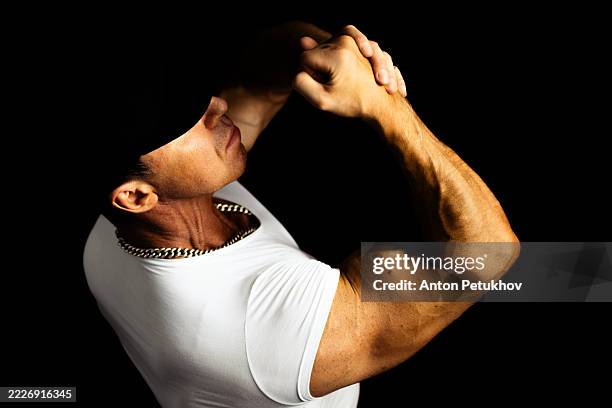 young athletic man in studio on black background. - macho photos et images de collection