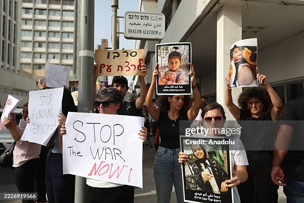People, holding banners, protest against Israeli attacks on Gaza and its starvation policy as they gather in front of the US Embassy in Tel Aviv,...