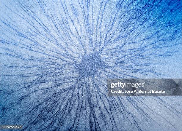 shiny blue metallic surface with an expanding stain. - levend organisme stockfoto's en -beelden