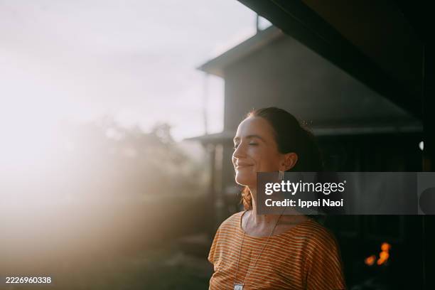 woman having eyes closed and relaxing at sunset - espoir photos et images de collection