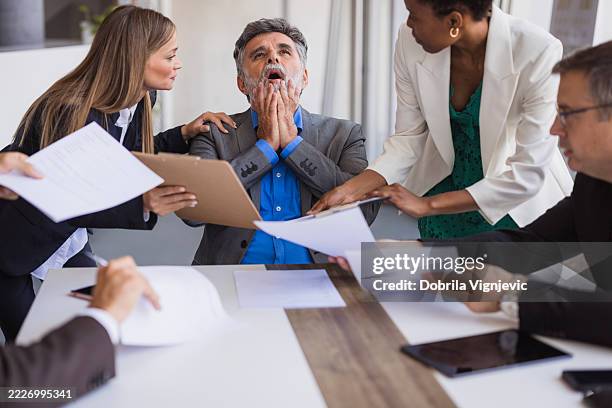 gestresster geschäftsmann, der während eines meetings mit kollegen eine panikattacke hat - folgen bewegungsaktivität stock-fotos und bilder