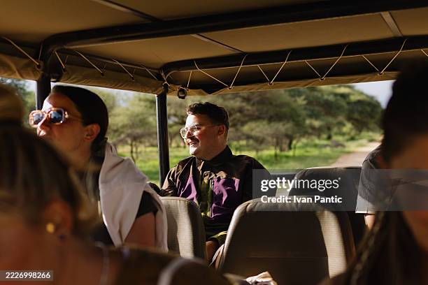 tourists enjoying safari tour in open top vehicle - masai mara national reserve stock pictures, royalty-free photos & images