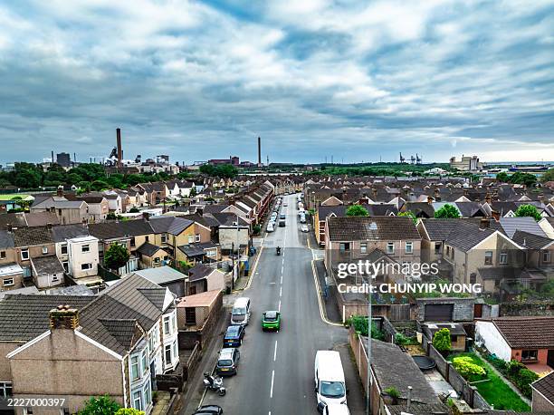 port talbot steelworks dominating the skyline over a residential area in south wales - council flat stock pictures, royalty-free photos & images