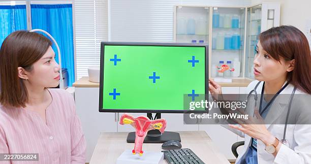 asian doctor use green screen explain womb - colposcopy stock pictures, royalty-free photos & images