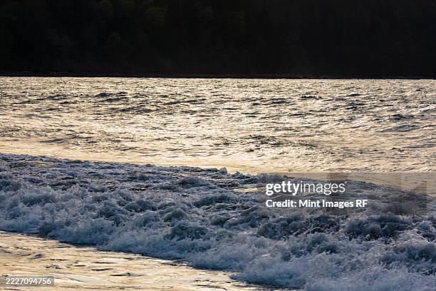 rough water on puget sound off seattle and the shadow of a vessel - pacifico occidentale foto e immagini stock