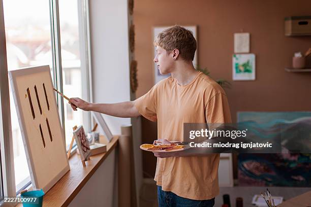 passionate artist painting at home - palet stockfoto's en -beelden
