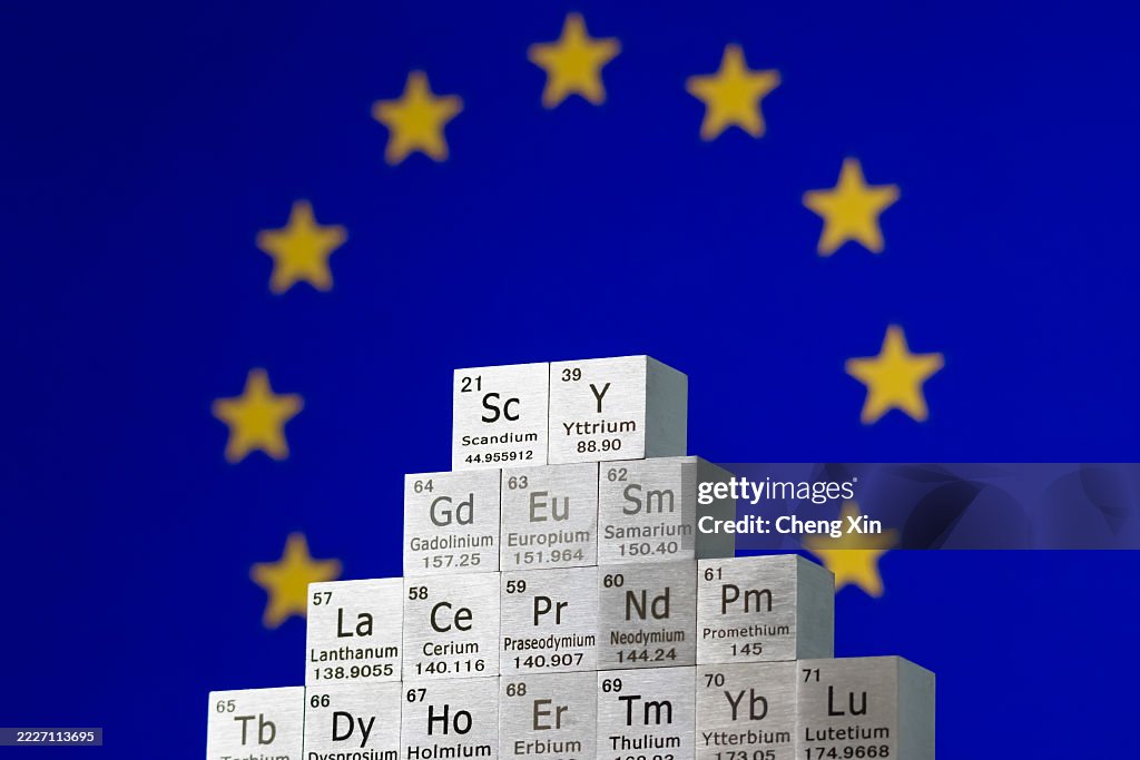 Rare earth element cubes stacked in front of European Union flag