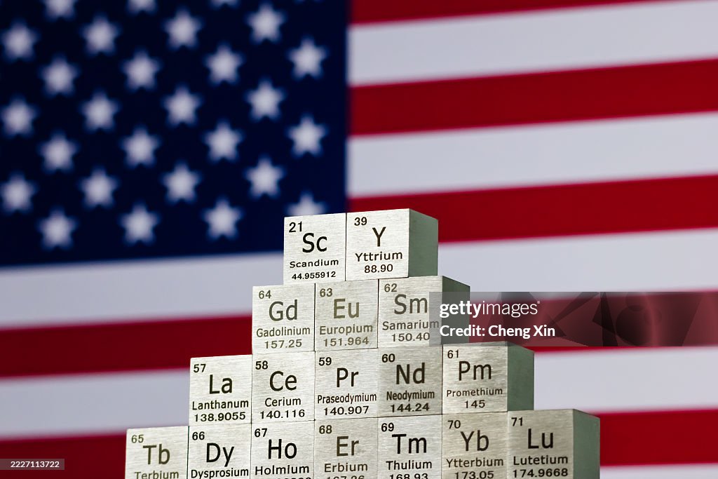 Rare earth element cubes in stepped formation with U.S. flag in background