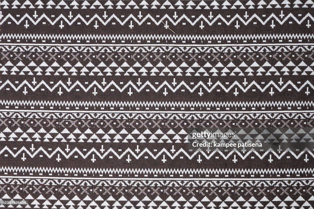A brown and white striped fabric with a pattern of triangles
