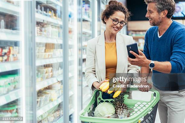 couple shopping in supermarket. - buy online pick up in store stock pictures, royalty-free photos & images
