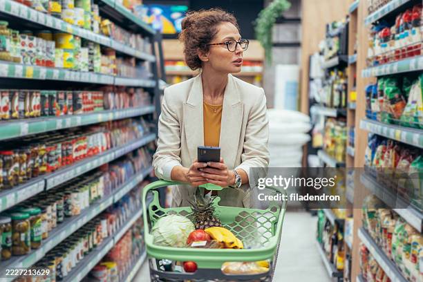 woman shopping in supermarket. - buy online pick up in store stock pictures, royalty-free photos & images