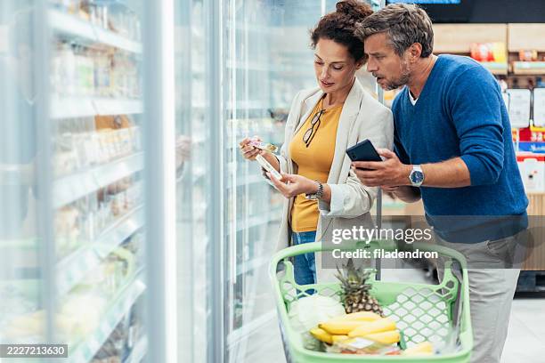 couple shopping in supermarket. - buy online pick up in store stock pictures, royalty-free photos & images