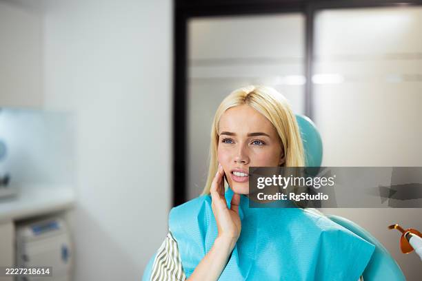 young woman suffering from toothache at the dentist office - human teeth stock pictures, royalty-free photos & images