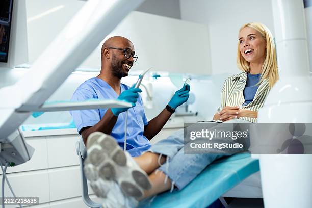 dentist showing to patient how to brush teeth correctly in dental clinic - dental mould stock pictures, royalty-free photos & images