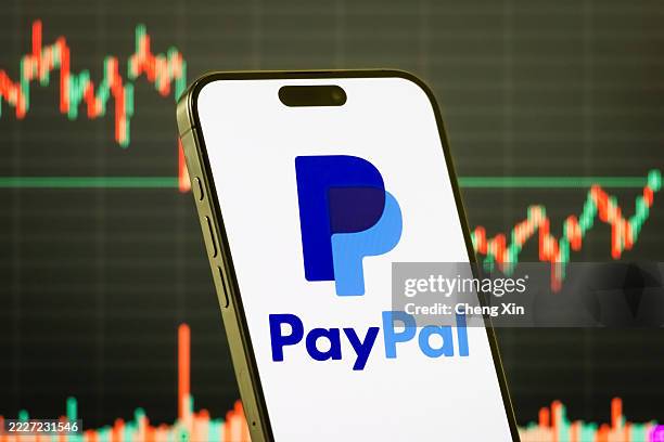 In this photo illustration, a smartphone displays the logo of PayPal Holdings Inc. , a leading global online payments and financial technology...
