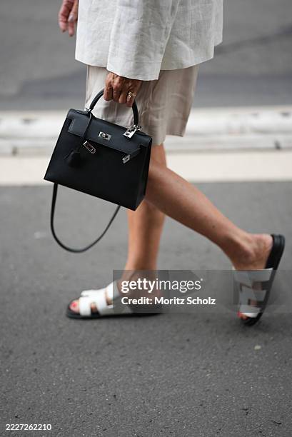 Angelika Hanel is seen wearing a pair of light beige bermuda shorts with relaxed fit and mid-thigh length from H&M; a fitted white scoop-neck basic...
