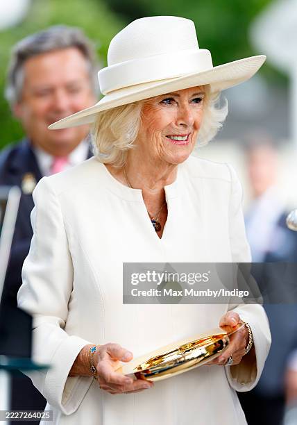 Queen Camilla presents the prizes to the winners of the 'King George VI and Queen Elizabeth Stakes' as she attends King George Day at Ascot...