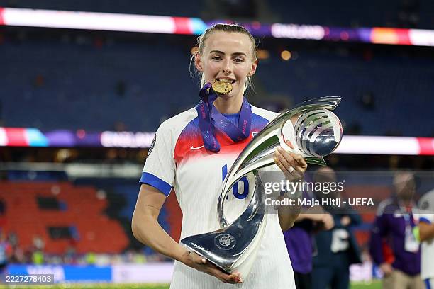 Chloe Kelly of England poses for a photograph with the UEFA Women's EURO trophy, while bitting her winners medal, after her team's victory in the...