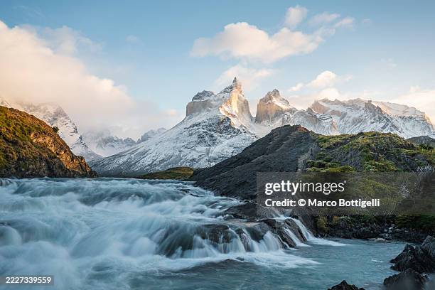 majestic mountain landscape with flowing river in torres del paine national park, chile - anden stock-fotos und bilder