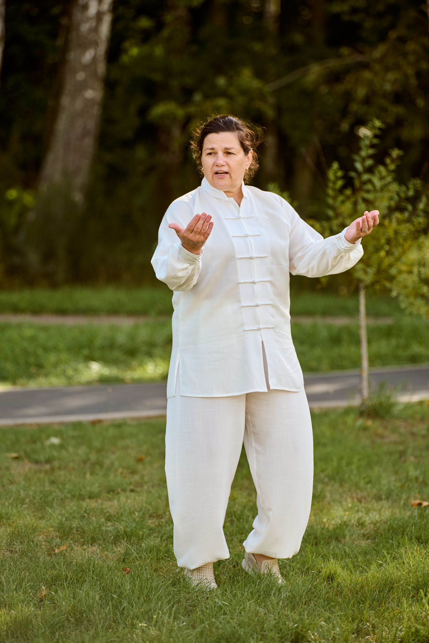 Mature caucasian woman practicing qigong in park on sunny day Mature caucasian woman practicing qigong in park on sunny day