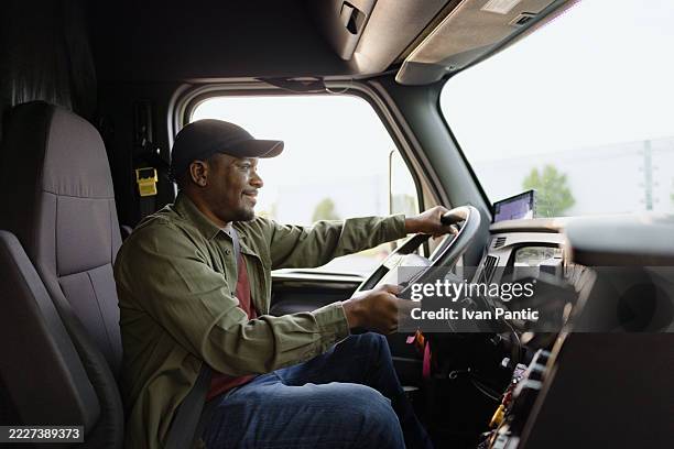 truck driver smiling while driving his truck - vrachtwagenchauffeur stockfoto's en -beelden