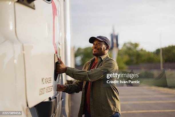 conducteur de camion ouvrant le réservoir de carburant se préparant pour un long voyage - véhicule utilitaire et commercial photos et images de collection