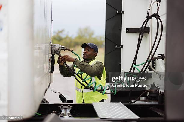 truck driver connecting refrigerated trailer hoses to his truck - refrigerator truck stock pictures, royalty-free photos & images