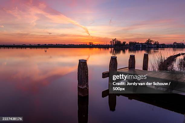 scenic view of lake against orange sky,weesp,netherlands - weesp stock pictures, royalty-free photos & images