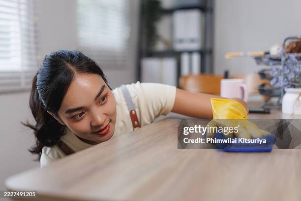 young woman cleaning a table with microfiber cloth and gloves - obsessive compulsive disorder organizing stock pictures, royalty-free photos & images