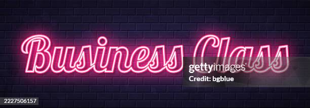 business class - glowing neon text on brick wall background - classroom wall stock illustrations