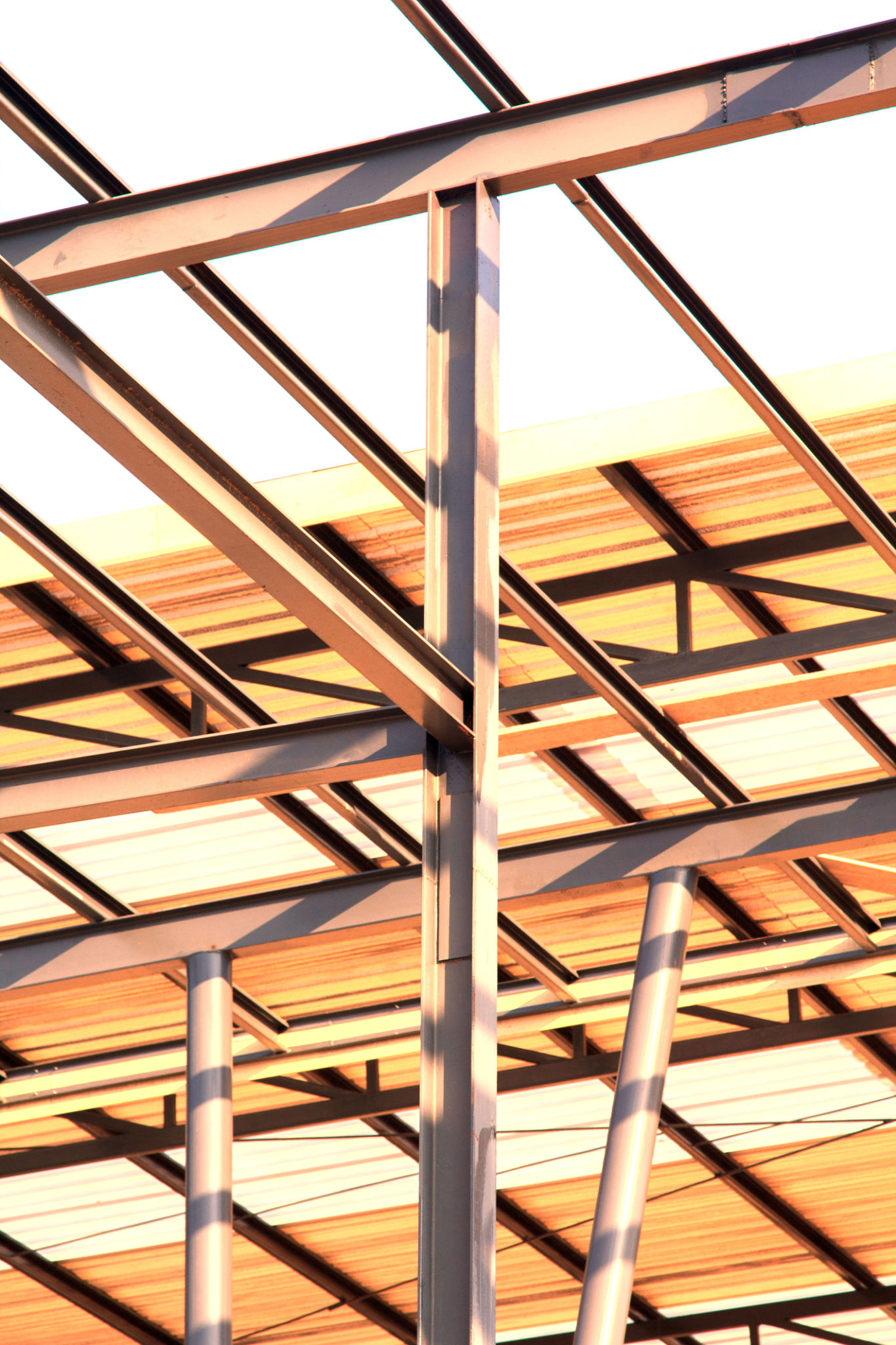 Metal roof structure on a modern building with a metal ladder on the wall and roof against the sky, highlighting architectural design Metal roof structure on a modern building with a metal ladder on the wall and roof against the sky, highlighting architectural design