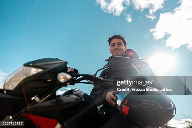retrato de un joven motociclista durante un paseo en moto al aire libre - motociclista fotografías e imágenes de stock