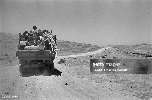 Displaced Palestinian refugees travel on a truck across a deserted area in Transjordan, 25th June 1949. Original Publication: Picture Post - 4818 -...