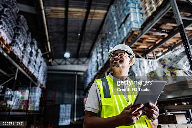 employé travaillant sur une tablette numérique dans un entrepôt - logistique photos et images de collection