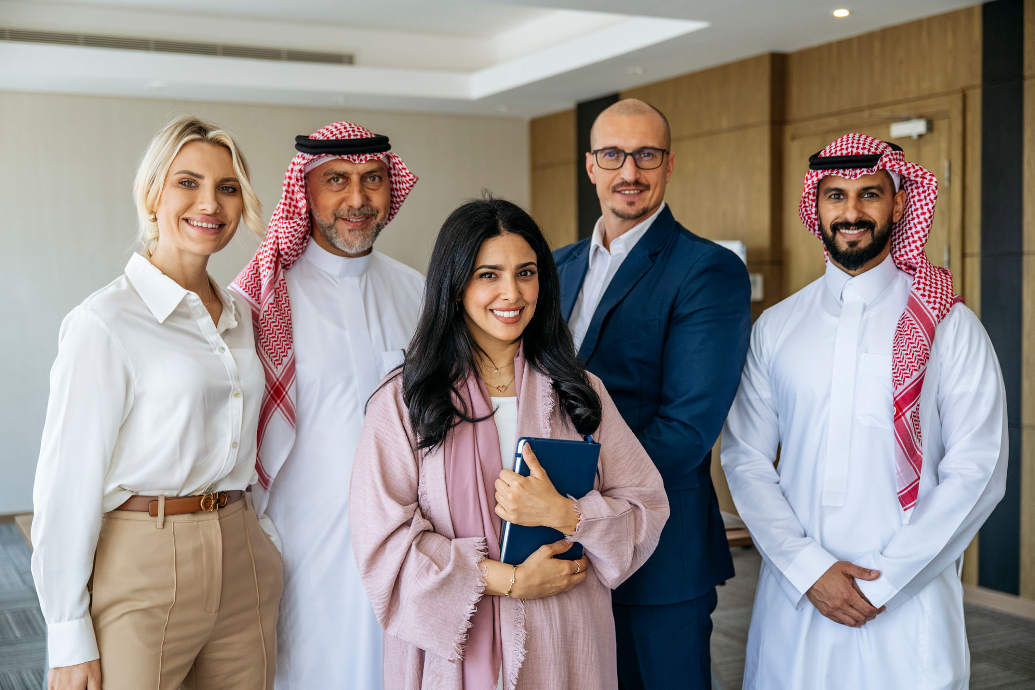 Portrait of five multi racial business partners in Middle East office smiling towards camera Portrait of five multi racial business partners in Middle East office smiling towards camera
