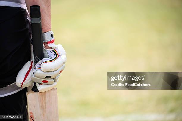 close up teenage girls hand gripping cricket bat - cricket bat stock pictures, royalty-free photos & images