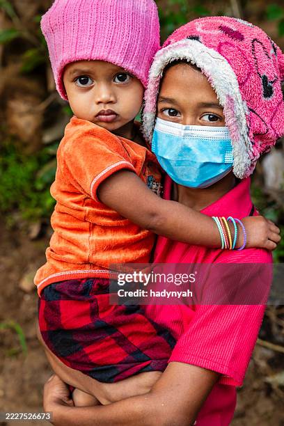 sri lankan young boy holding his little sister, sigiriya - bescherming tegen corona stockfoto's en -beelden