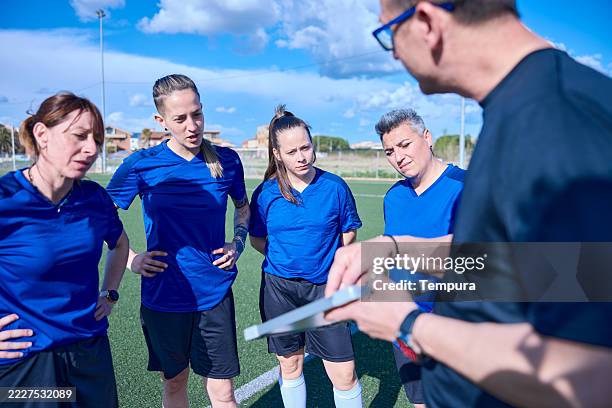 l'allenatore sta delineando il piano di gioco e la strategia su un blocco per appunti. - calcio femminile foto e immagini stock
