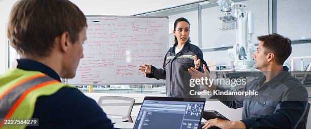 white latin industrial engineer man and woman work together, discussing in meeting room factory with laptop and whiteboard. mechanical industry engineering business. blue collar worker, technology job - staff meeting stock pictures, royalty-free photos & images