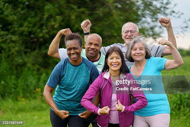 group of seniors posing outdoors while celebrating health and fitness - verouderingsproces stockfoto's en -beelden