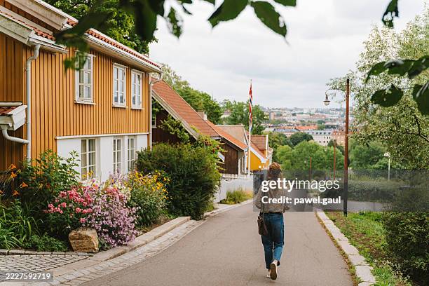 woman walking through st. hanshaugen district, oslo, norway - noorse cultuur stockfoto's en -beelden