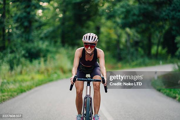 giovane ciclista che si gode un giro su una strada di campagna - ciclista foto e immagini stock