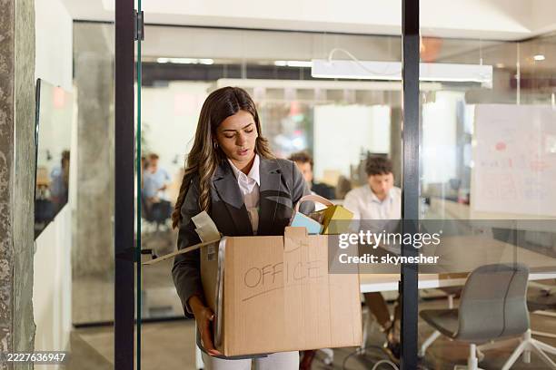 empresaria disgustada saliendo de la oficina con sus pertenencias después de ser despedida. - despedida fotografías e imágenes de stock