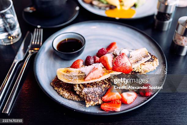 healthy vegan oatmeal pancakes with fresh berries served for breakfast at a restaurant - raspberry syrup stock pictures, royalty-free photos & images