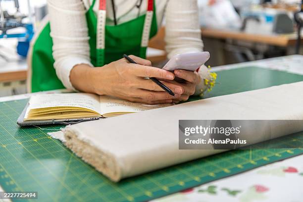 seamstress in a sewing workshop - linhas texteis imagens e fotografias de stock