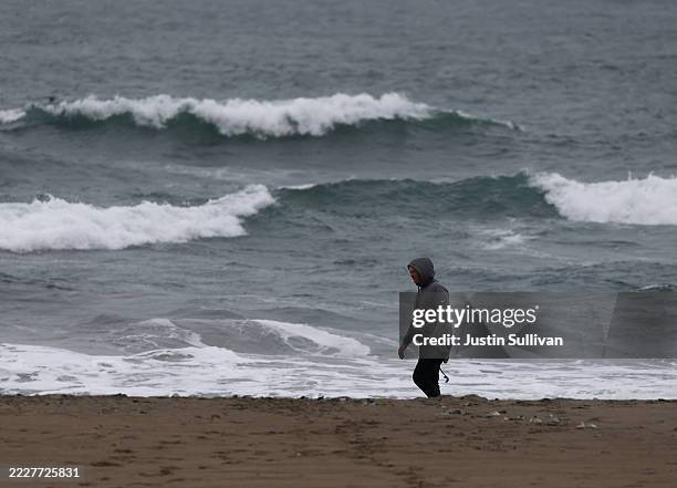 Beachgoer walks on the beach during a tsunami advisory at Ocean Beach on July 30, 2025 in San Francisco, California. Authorities are warning people...
