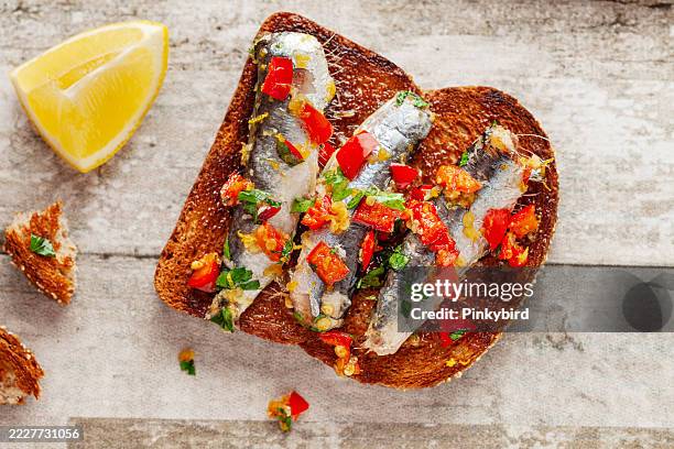 bruschetta et sardine, sandwich aux sprats fumés. petits sandwichs aux sardines. sandwichs aux sardines sur des tranches de pain grillées. sandwich à la sauce à la sardine et à l’avocat. - sardine photos et images de collection